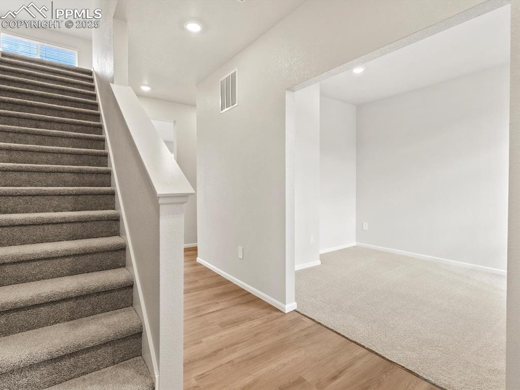 Image 12 of 24: Staircase featuring wood finished floors and recessed lighting