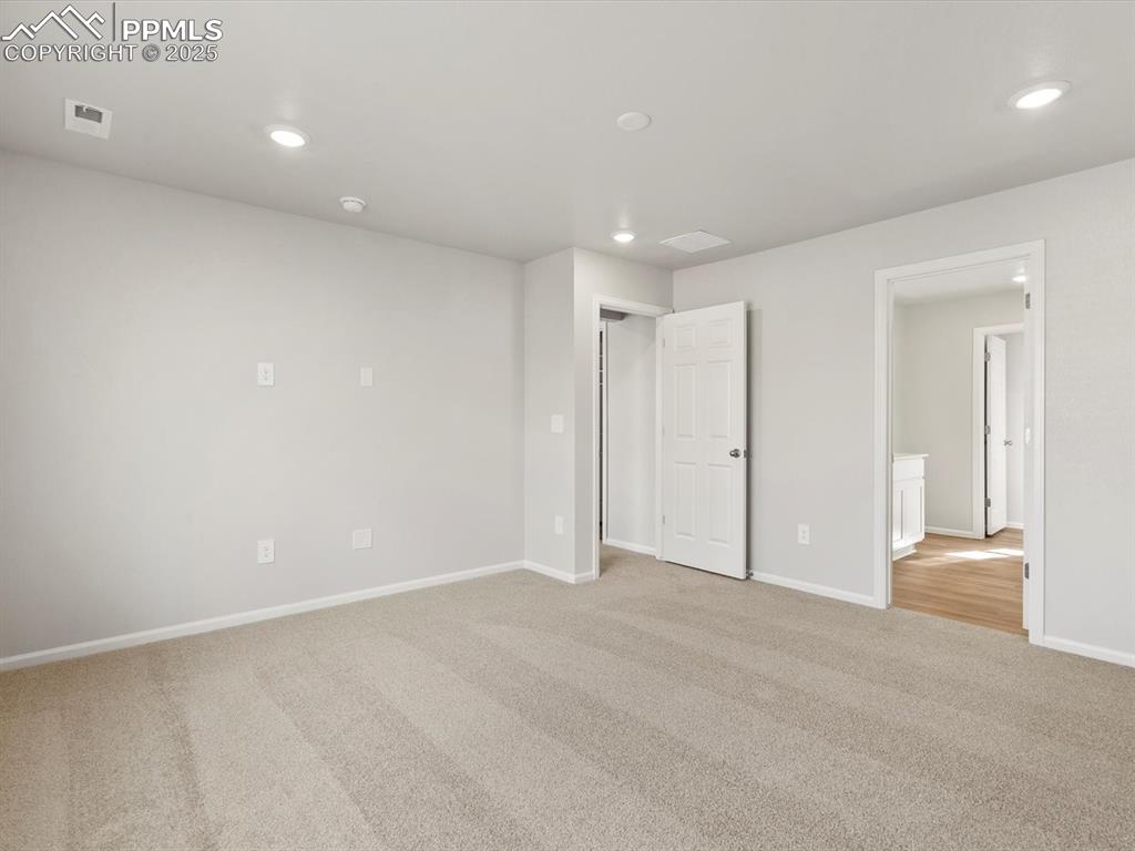 Image 17 of 24: Unfurnished bedroom featuring light carpet and recessed lighting