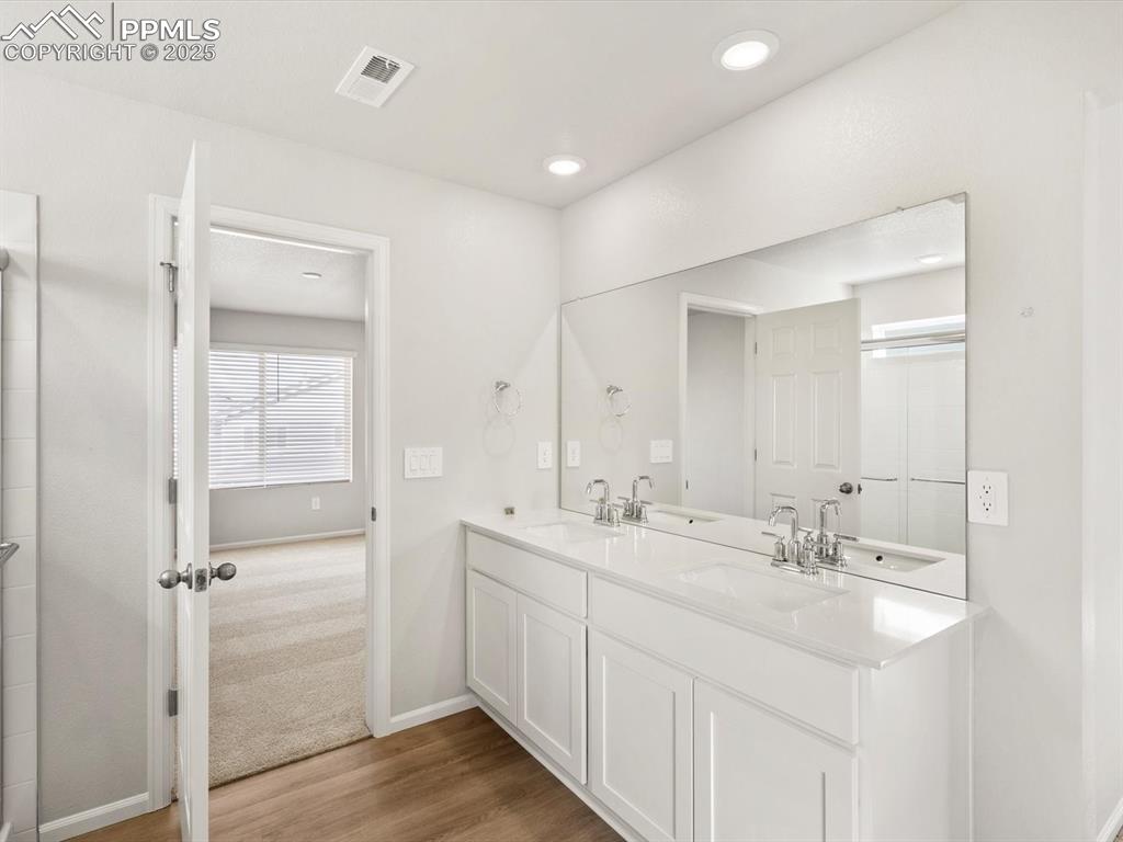 Image 19 of 24: Full bathroom featuring double vanity, light wood finished floors, and a sh
