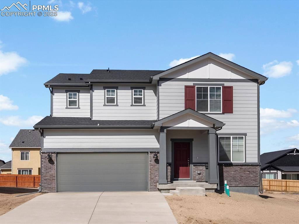 Image 2 of 24: View of front of home featuring brick siding, an attached garage, concrete 