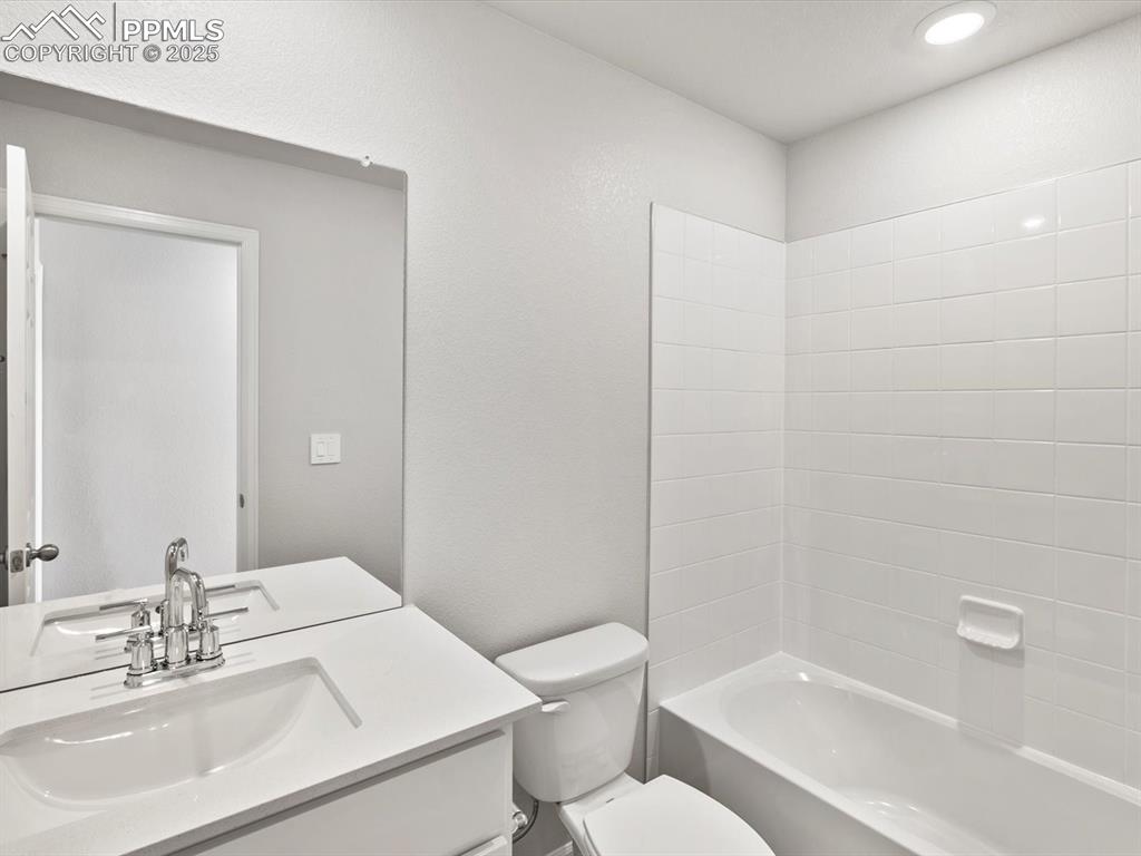 Image 24 of 24: Full bath featuring vanity, shower / washtub combination, and a textured wa