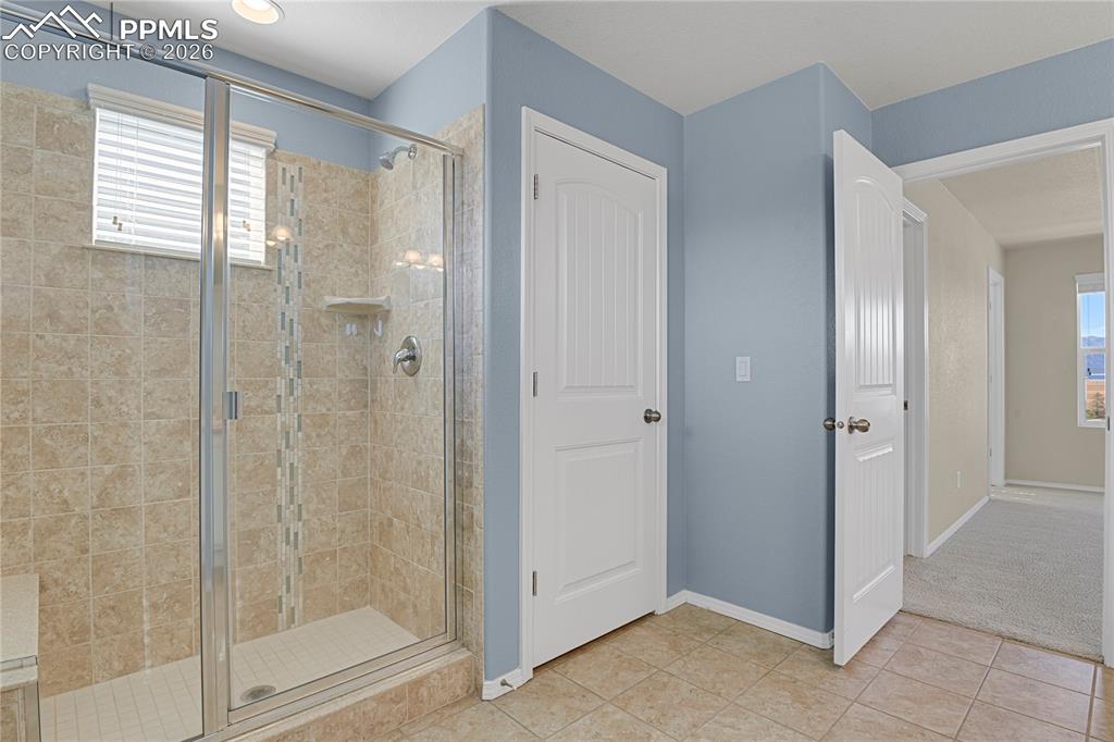Image 16 of 41: Shower with bench and linen closet for additional storage