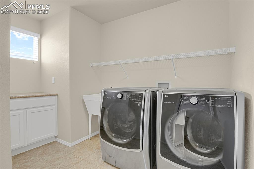 Image 18 of 41: Convenient upper level laundry with utility sink.