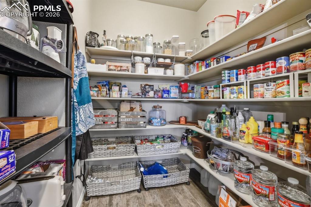Image 15 of 49: HUGE walk-in pantry with wood shelving