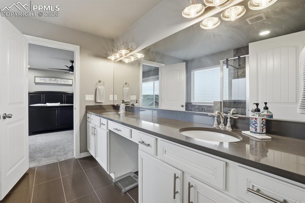 Image 24 of 49: quartz countertops, double vanity, updated lighting