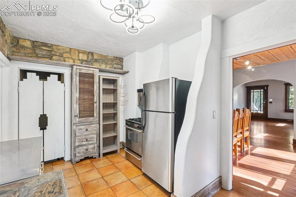 Image 12 of 36: Custom kitchen with gas burning stove, stone countertops and custom cabinet