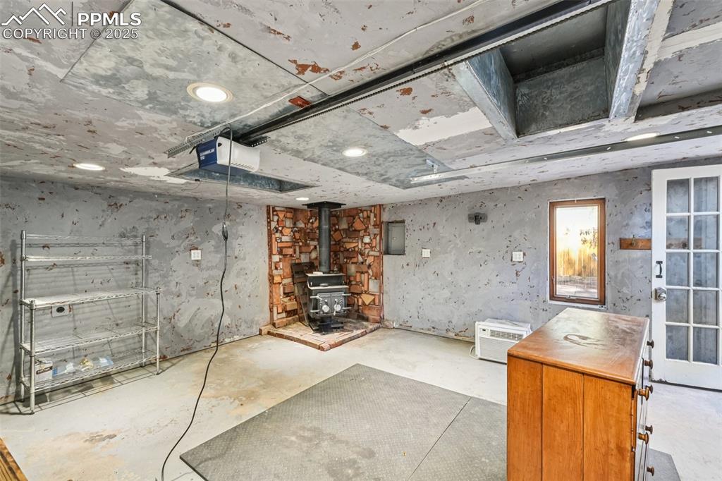 Image 27 of 36: Garage with wood burning stove