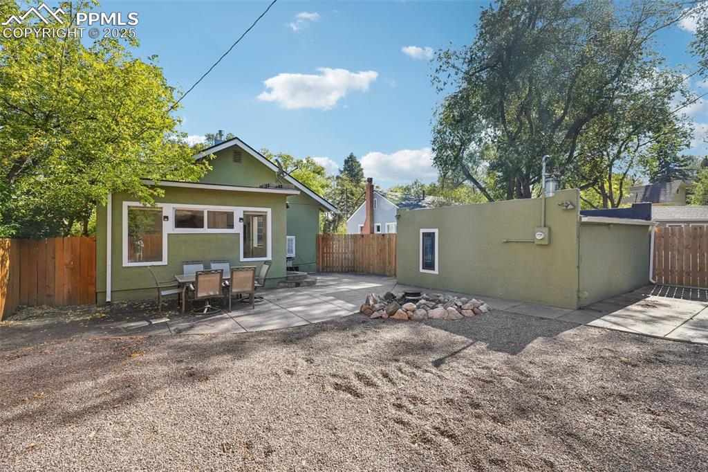 Image 28 of 36: Xeriscaped backyard with spacious patio and fire pit