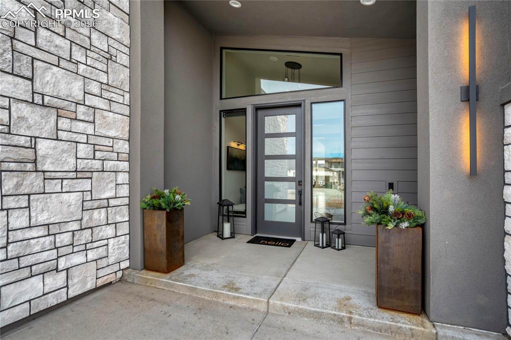 Image 3 of 50: A glass-inset entry introduces the home with architectural simplicity and c