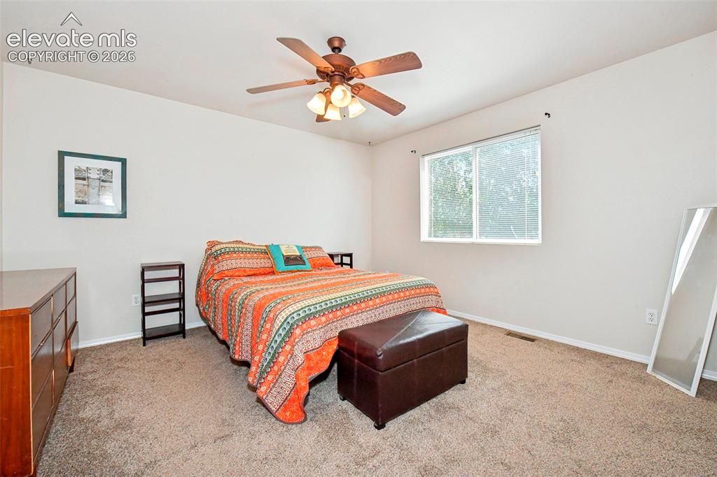 Image 15 of 26: Primary bedroom with view of back yard.