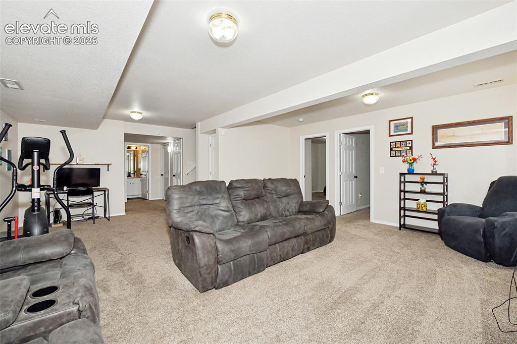 Image 20 of 26: Large family room in basement.