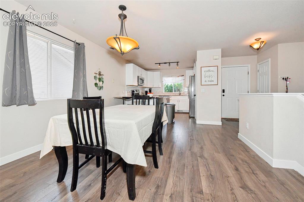 Image 9 of 26: Dining area with view of kitchen, front door and closet.
