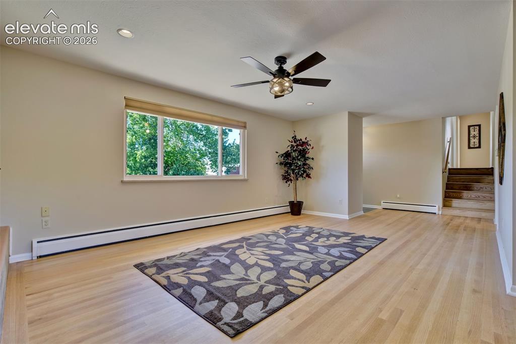 Image 10 of 50: Neutral-toned living space featuring light wood-finish flooring, a ceiling