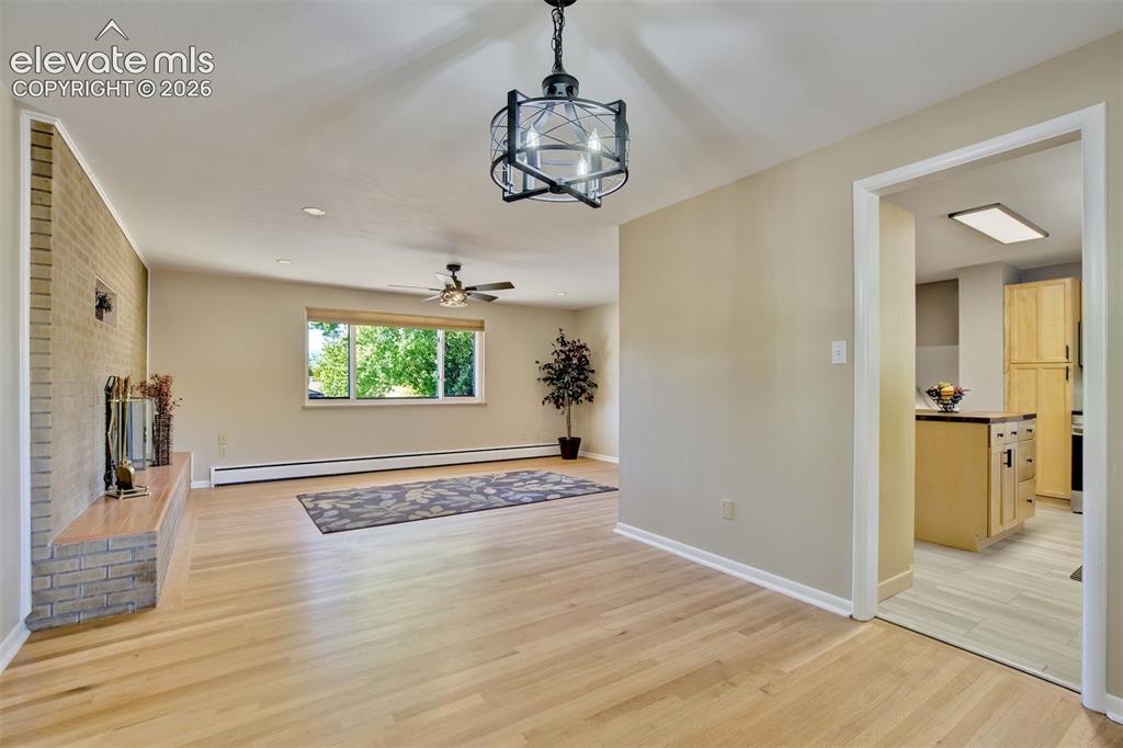 Image 13 of 50: Living space featuring wood-finish flooring, a floor-to-ceiling brick heart