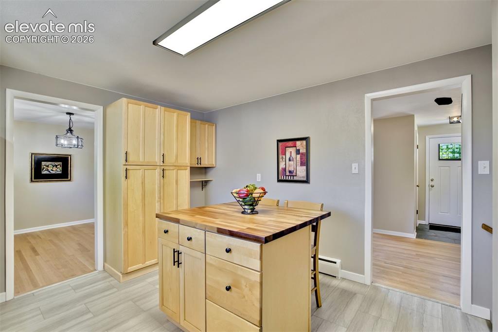 Image 17 of 50: Custom light-toned wood cabinetry, center island with a wood-block surface,
