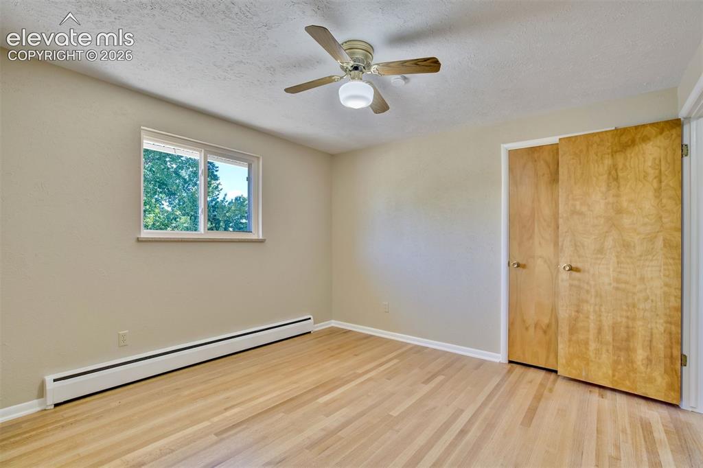 Image 23 of 50: Room featuring wood-finish flooring, a ceiling fan with integrated lighting