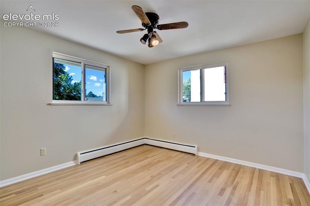 Image 25 of 50: Neutral wall tones, wood-finish flooring, dual sliding windows, and a ceili