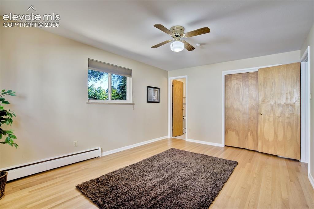 Image 29 of 50: Room with wood-finish flooring, ceiling fan with integrated light fixture, 