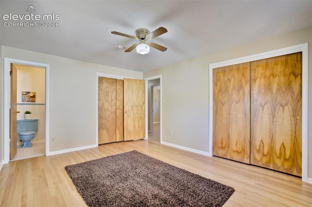 Image 30 of 50: Wood-finish flooring, dual built-in closets with wood-grain doors, and a ce