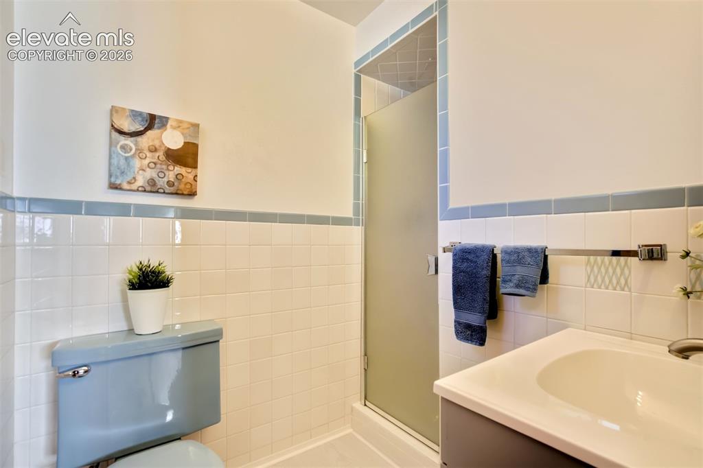 Image 31 of 50: Bathroom featuring a vanity with integrated sink, shower enclosure with fro