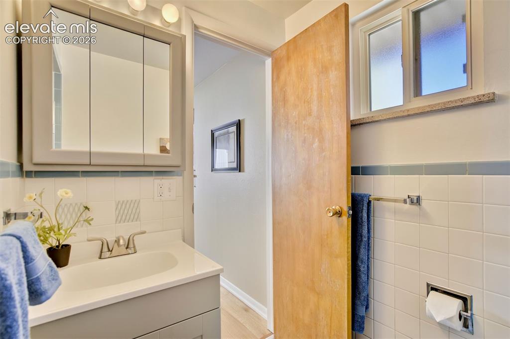 Image 32 of 50: Neutral-toned vanity with an integrated basin, mirrored medicine cabinet, w