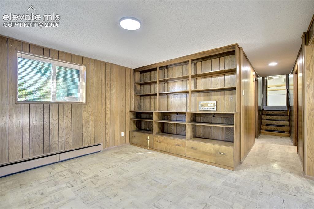 Image 34 of 50: Interior space featuring wood paneling, floor-to-ceiling built-in wooden ca