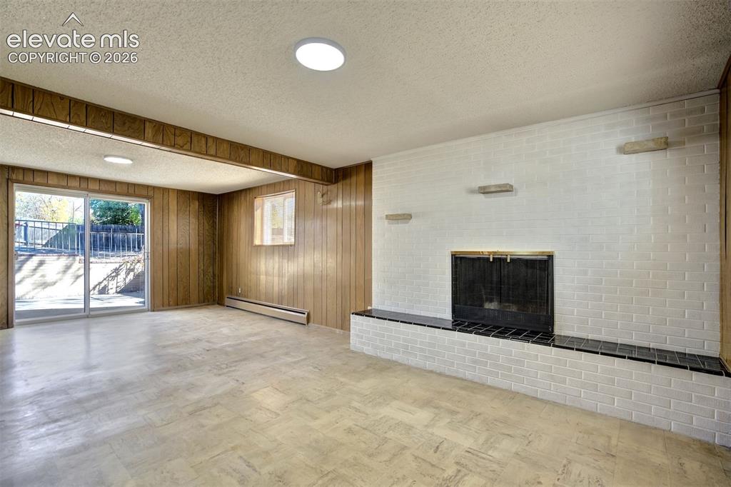 Image 35 of 50: Fireplace featuring a white-painted brick surround and a black tiled hearth