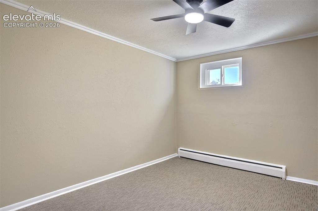 Image 39 of 50: Interior space featuring neutral wall tones, crown molding, patterned carpe