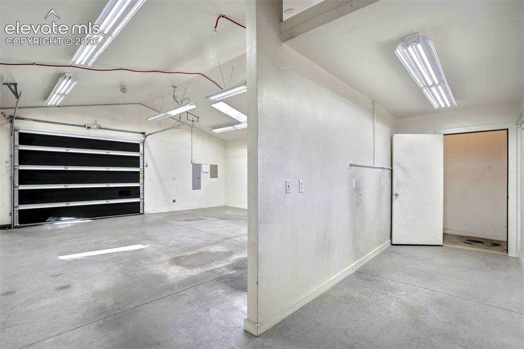 Image 46 of 50: Multi-bay garage featuring concrete flooring, a sectional metal overhead do