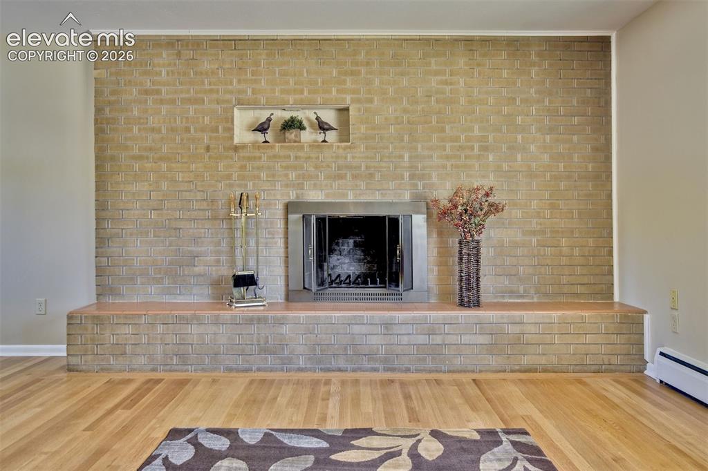Image 8 of 50: Full-height masonry brick fireplace featuring a tiered hearth, metal firebo