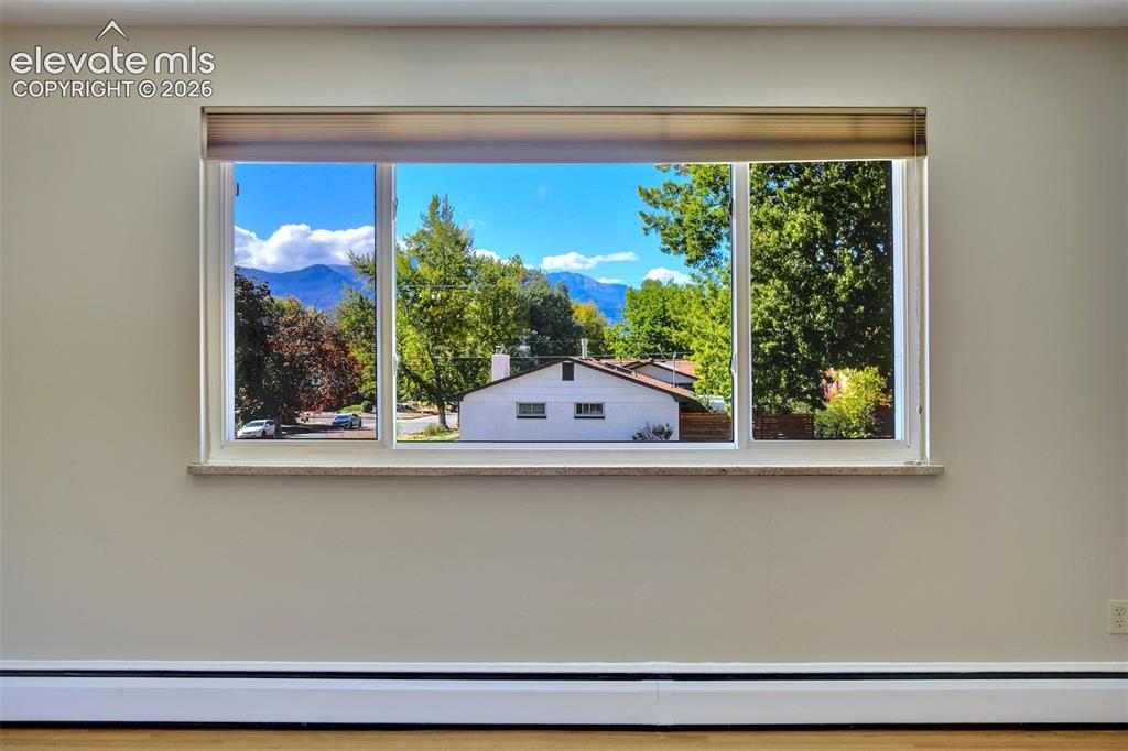 Image 9 of 50: Large picture window with a stone-finish sill, showcasing a mountain backdr