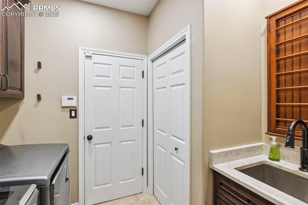 Image 18 of 44: Laundry area featuring cabinet space, washer and clothes dryer, and a textu