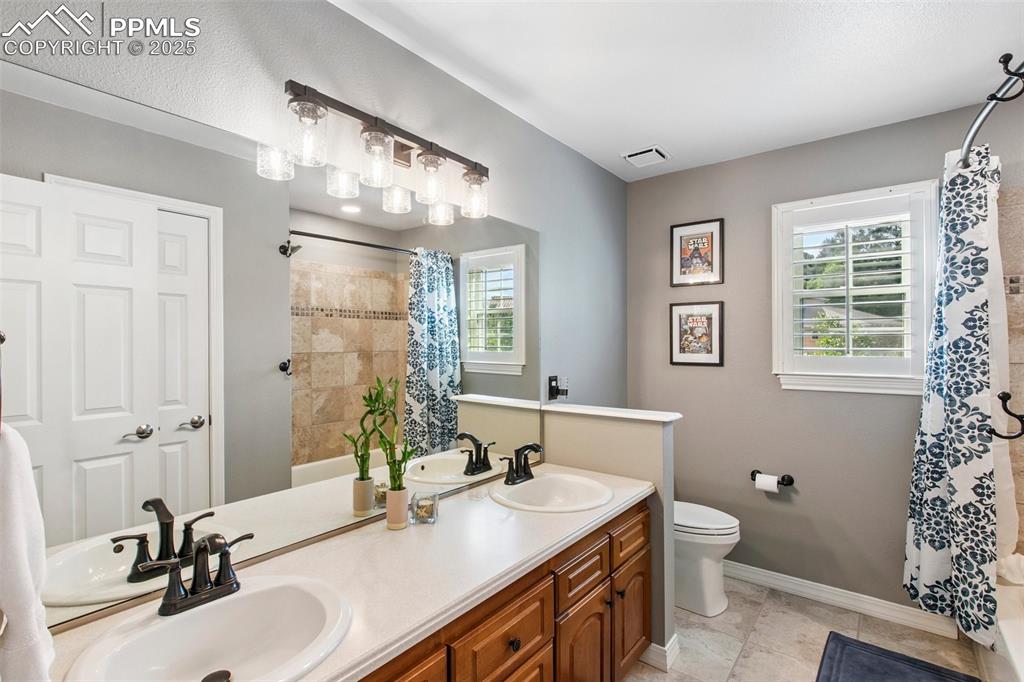 Image 26 of 44: Full bathroom with double vanity and toilet