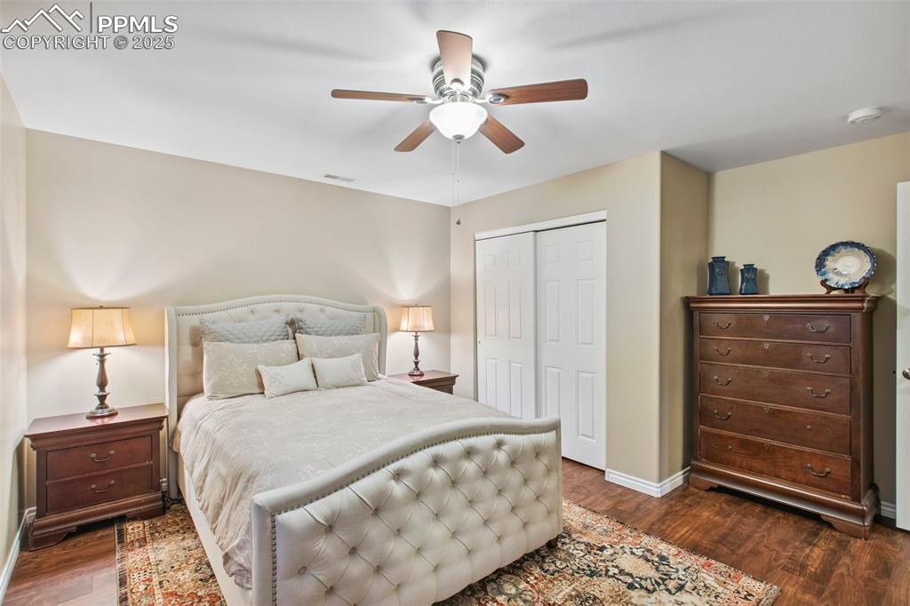 Image 29 of 44: Bedroom with dark wood finished floors, a closet, and a ceiling fan