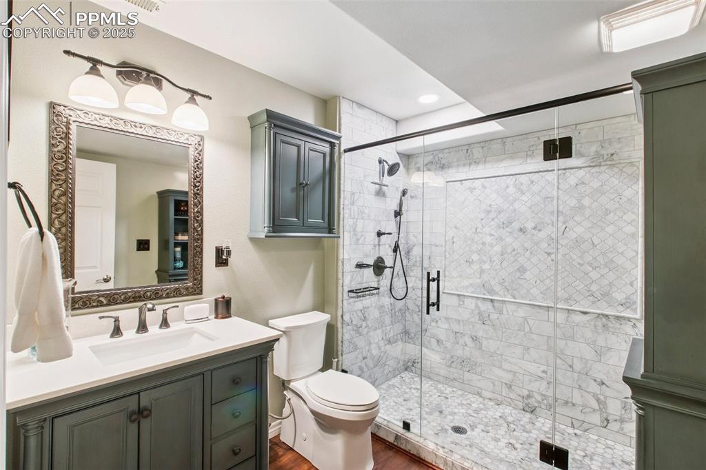 Image 30 of 44: Full bathroom with vanity, a stall shower, wood finished floors, and recess
