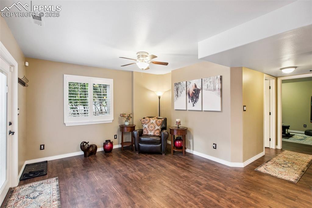 Image 35 of 44: Living area with wood finished floors and ceiling fan