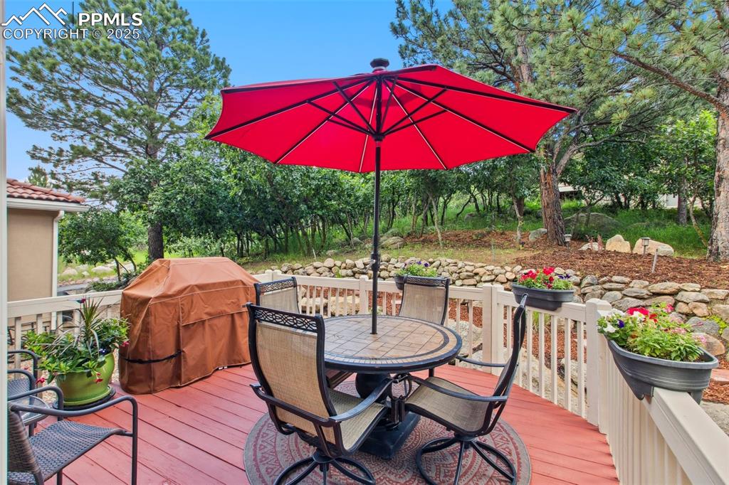 Image 38 of 44: Wooden terrace featuring outdoor dining space and grilling area