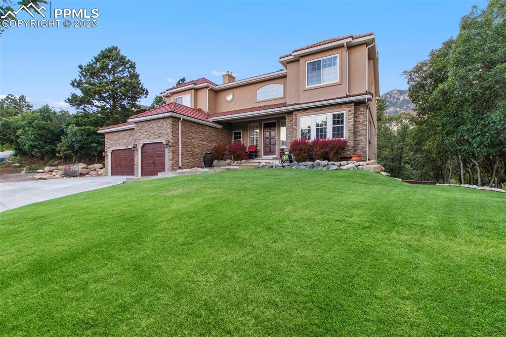 Image 5 of 44: View of front of home featuring a front lawn, a chimney, stucco siding, and