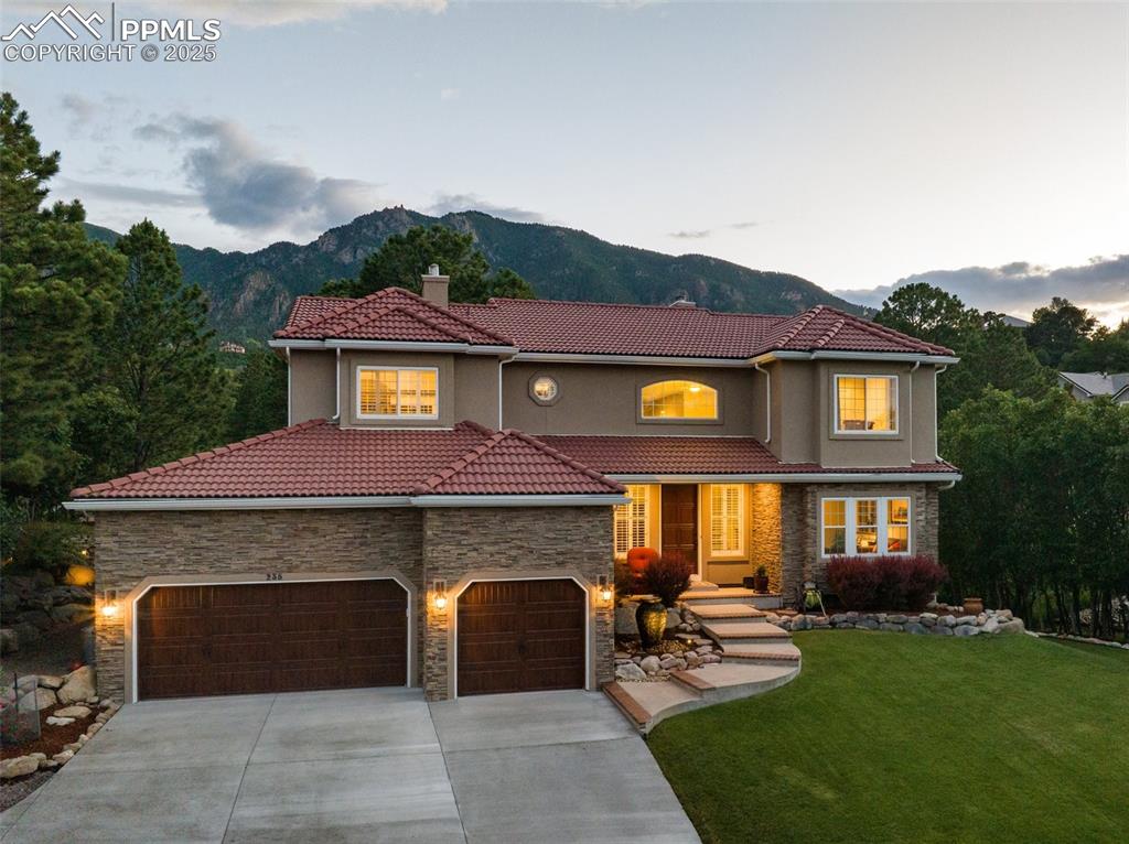 Image 6 of 44: Mediterranean / spanish home featuring concrete driveway, a tile roof, ston