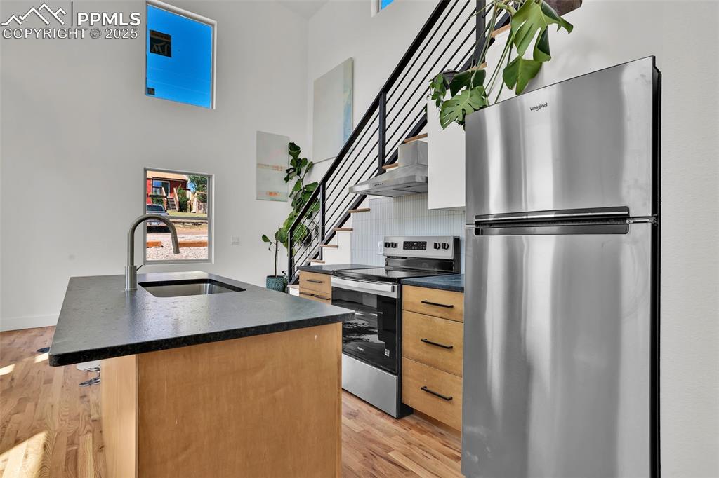 Image 12 of 49: Kitchen featuring appliances with stainless steel finishes, an island with