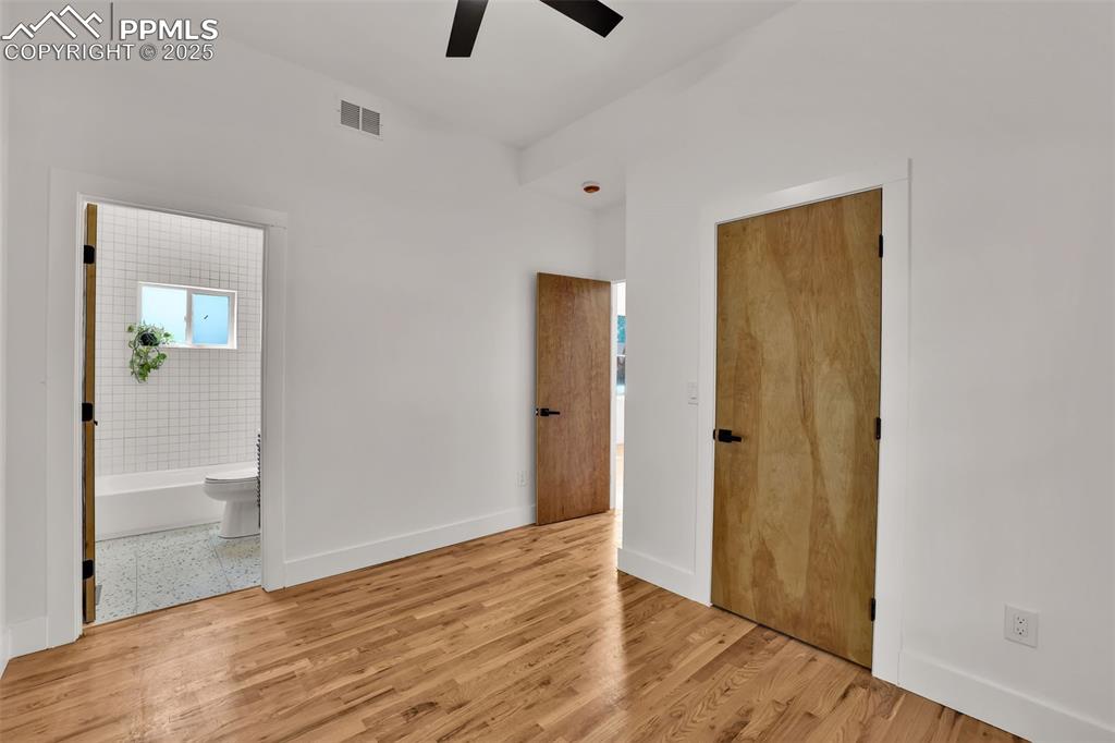 Image 16 of 49: Unfurnished bedroom featuring wood finished floors, a ceiling fan, and conn