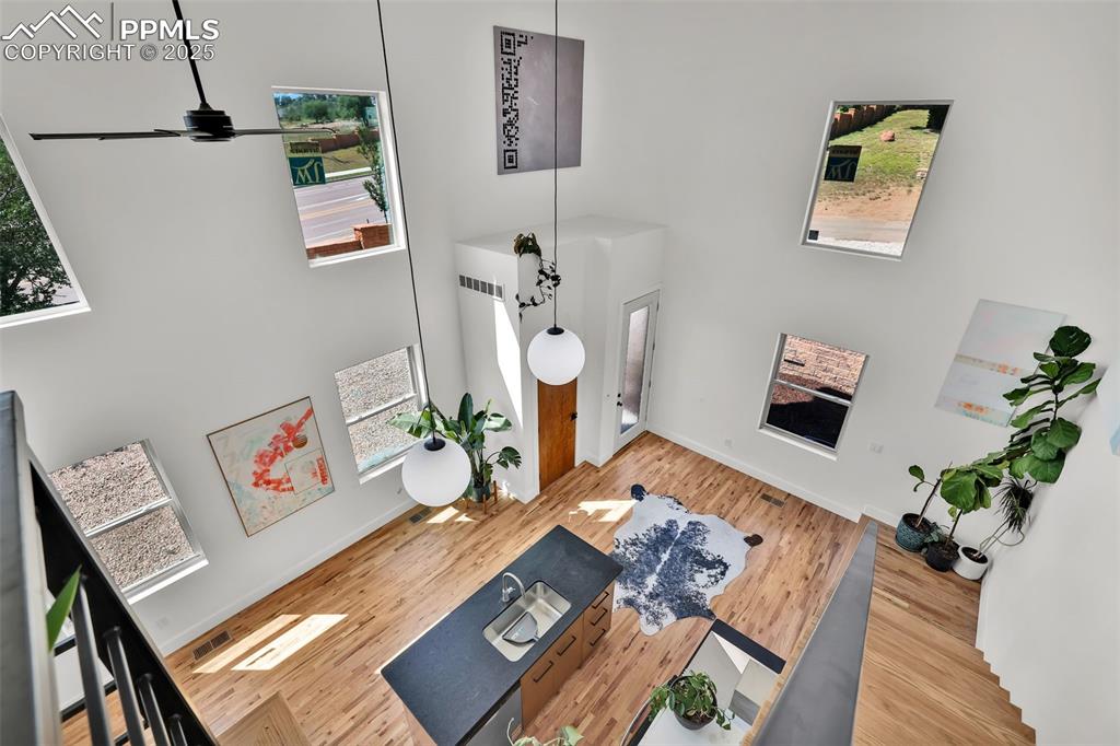 Image 19 of 49: Living room featuring a high ceiling and wood finished floors