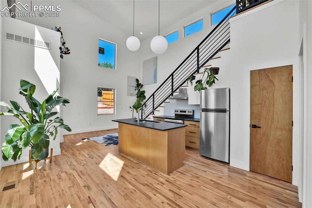 Image 2 of 49: Kitchen featuring an island with sink, appliances with stainless steel fini
