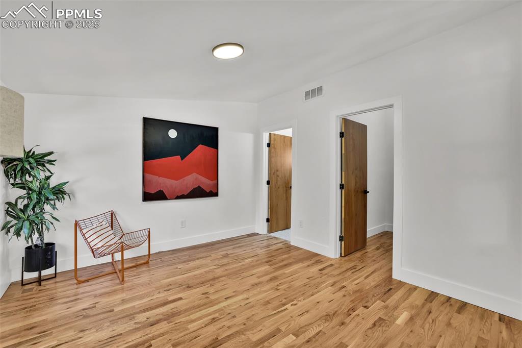 Image 20 of 49: Living area with light wood-style flooring and baseboards
