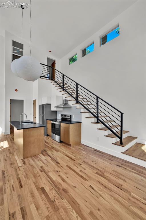 Image 24 of 49: Kitchen with a towering ceiling, stainless steel appliances, a kitchen isla
