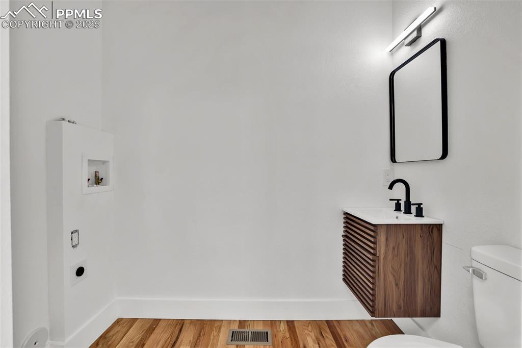 Image 31 of 49: Bathroom with light wood-style flooring and vanity
