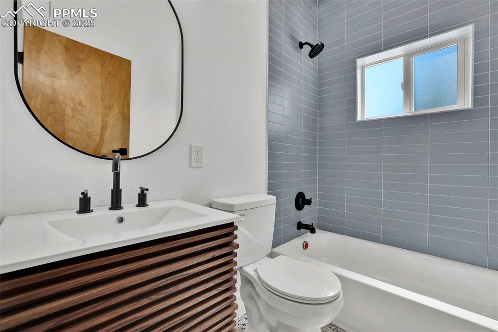 Image 39 of 49: Bathroom with shower / bathtub combination and vanity