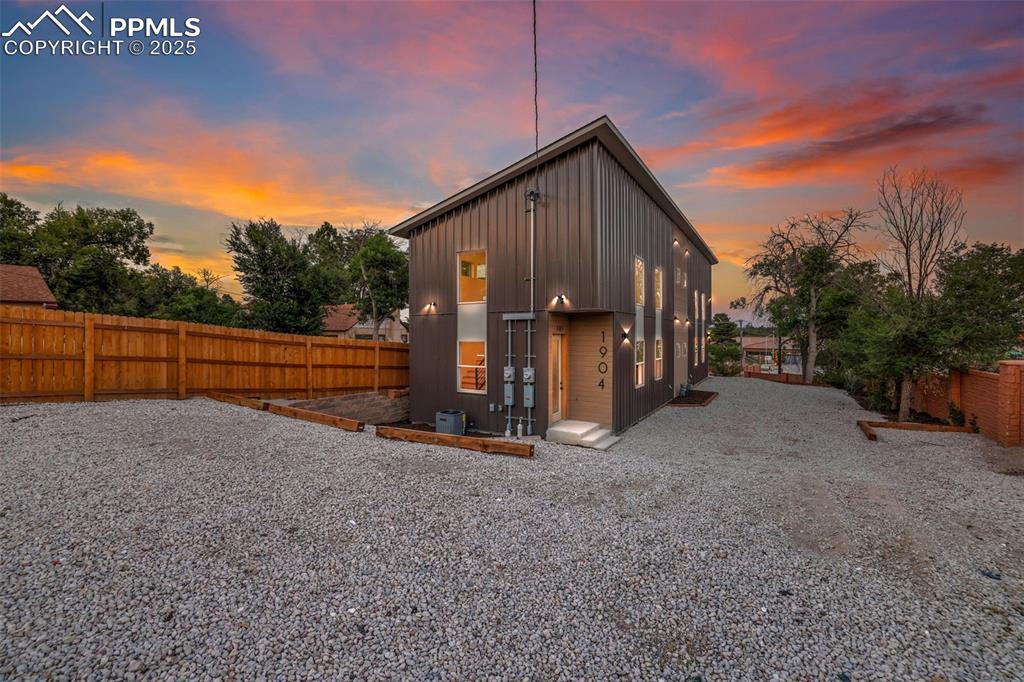 Image 45 of 49: Rear view of property with a fenced backyard, board and batten siding, and