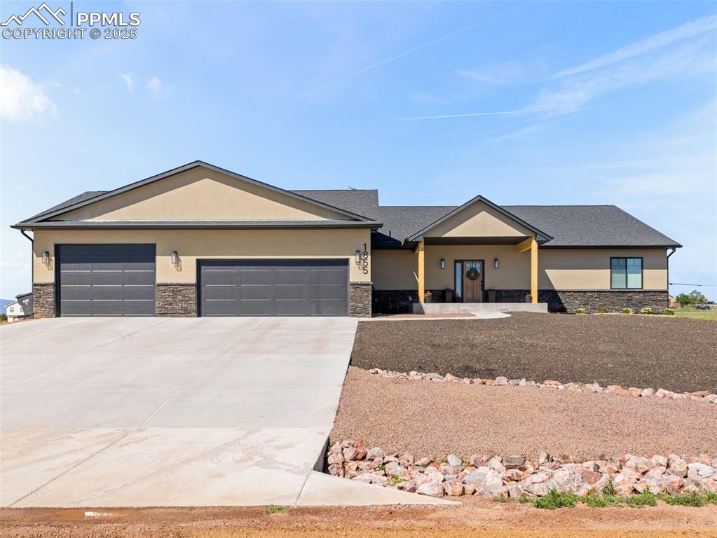 Image 1 of 48: View of front facade with stone siding, stucco siding, an attached garage, 
