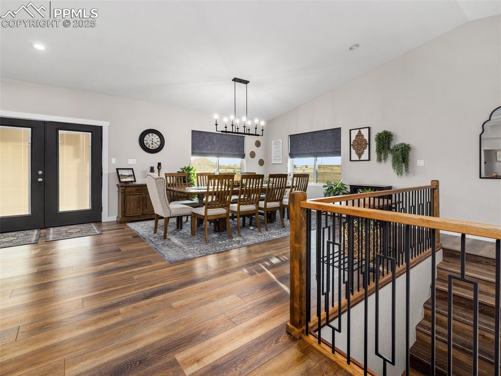 Image 12 of 48: Dining space featuring lofted ceiling, wood finished floors, french doors, 